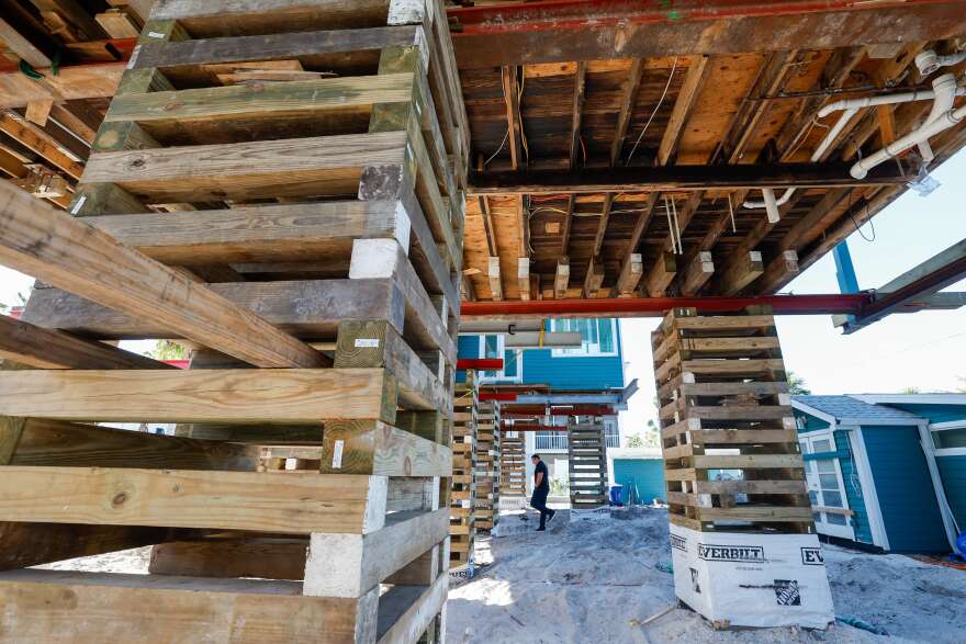 A house being elevated. The wooden supports used in the process look like Jenga pieces.