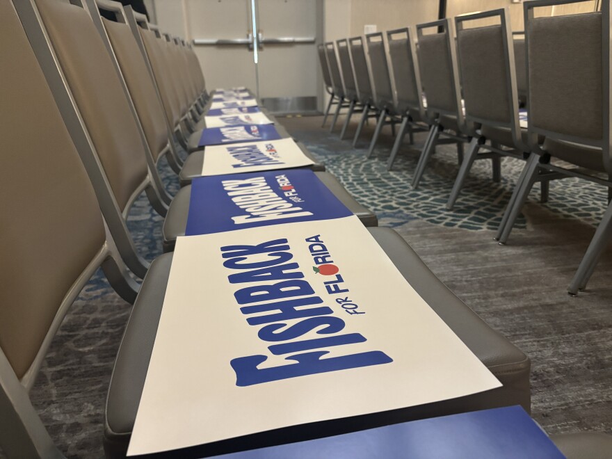 Fishback signs lined up on empty chairs ahead of the candidates speech at a Fort Lauderdale hotel ballroom on June 27, 2026.