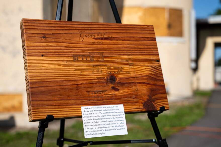 Wooden plaque on stand outside a house