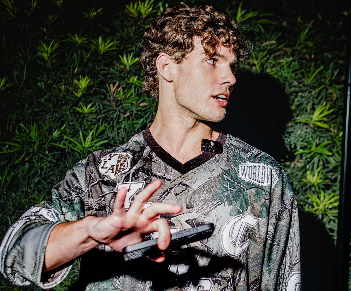 A young man puts his hand in front of a camera