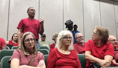 Speakers in red oppose a proposed Daily's gas station, convenience store and car wash in Fruit Cove.