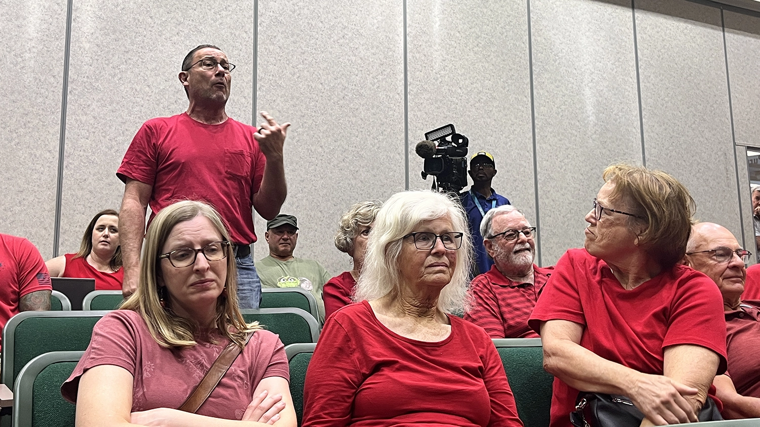 Speakers in red oppose a proposed Daily's gas station, convenience store and car wash in Fruit Cove.