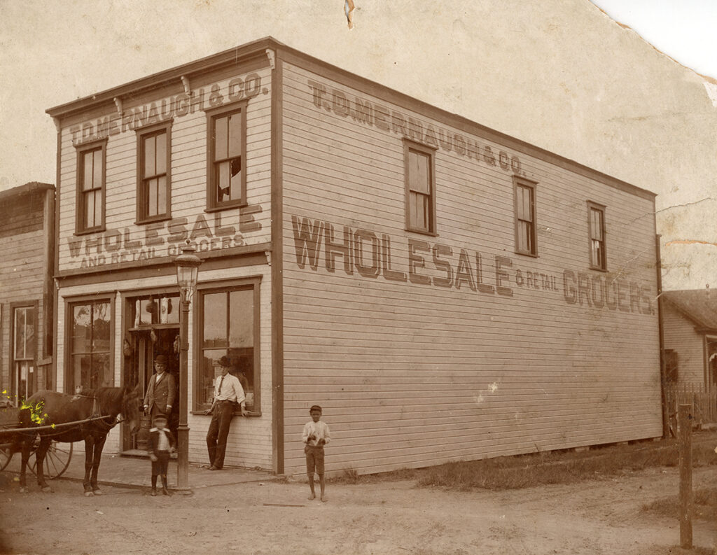Photo shows wood building from downtown Orlando in the 1890s with a horse, 2 men and 2 boys