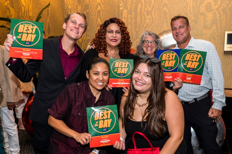 WMNF's Big Gay Radio Show hosts holding up their 'Best of the Bay 2025' award certificates at Creative Loafing's annual event.