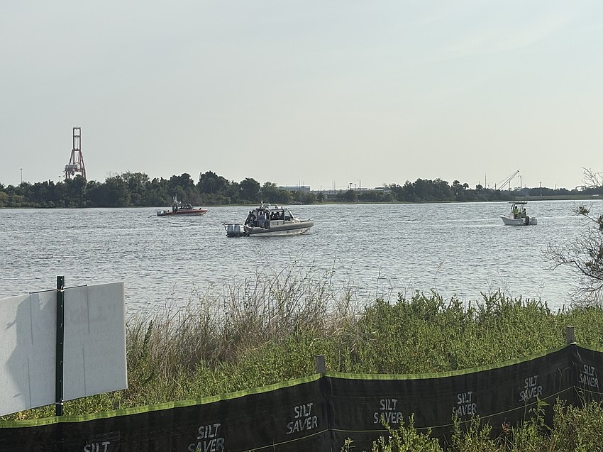 Boats from the U.S. Coast Guard, the Jacksonville Fire and Rescue Department and the Jacksonville Sheriff’s Office patrol the St. Johns River during helicopter work to raise JEA power lines overhead.