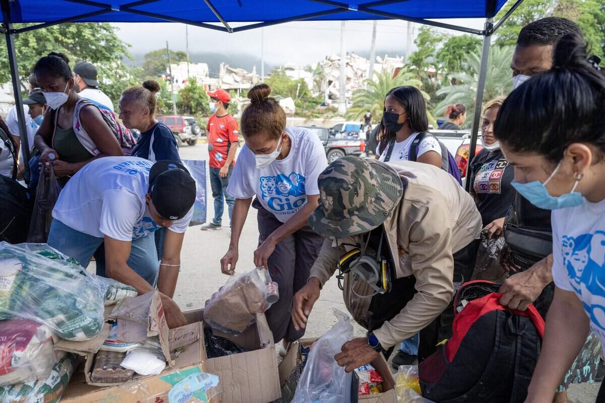 Volunteers distribute food and essential items in Caraballeda, La Guaira state, Venezuela, on June 30, 2026, following the June 24 twin earthquakes. Tens of thousands of people urgently need food and shelter in Venezuela due to the devastation from two huge earthquakes that killed more than 1,700 and injured 5,000, the UN said on June 30, as doctors warned of potential outbreaks of disease. (Photo by Miguel MEDINA / POOL / AFP via Getty Images)