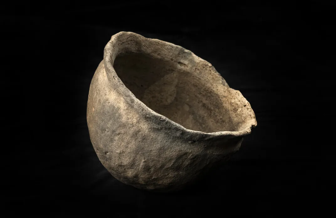 A piece of pottery against a black backdrop
