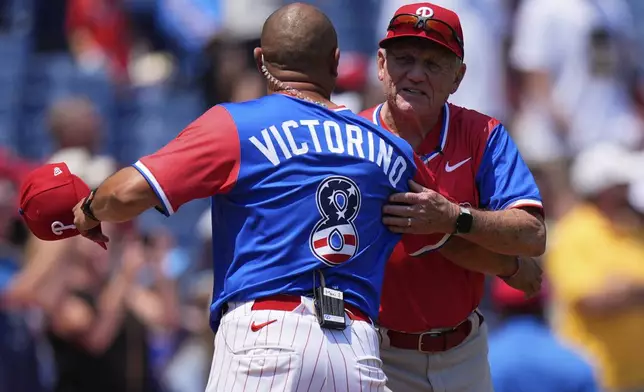 Shane Victorino, left, coach of the National League embraces Larry Bowa, coach of the American League, ahead of the MLB All-Star Futures baseball game Sunday, July 12, 2026, in Philadelphia. (AP Photo/Chris Szagola)