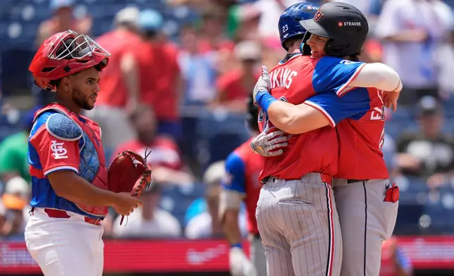 American League's Nathan Flewelling, right, embraces American League's Walker Jenkins after Flewelling hit a two-run home run as National League's Rainiel Rodriguez looks on in the sixth inning of the MLB All-Star Futures baseball game Sunday, July 12, 2026, in Philadelphia. (AP Photo/Chris Szagola)
