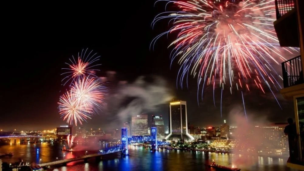 Fireworks explode in the sky over the Jacksonville skyline.