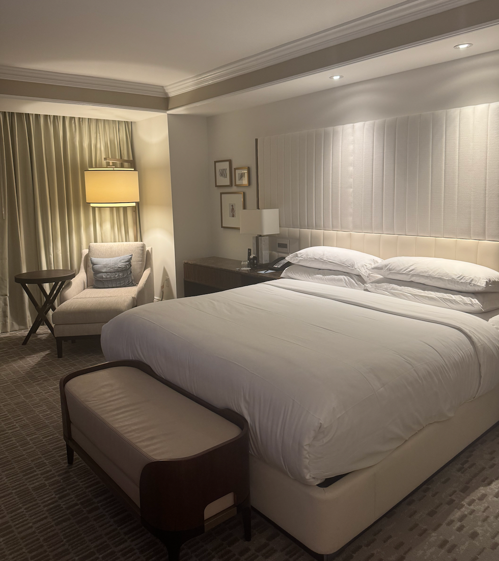 ritz carlton orlando hotel room with king sized bed, armchair, and bedside lamps. ritz carlton orlando hotel room with king sized bed, armchair, and bedside lamps.