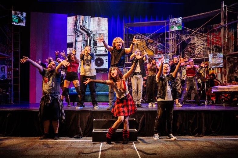 Musical improv performers live on stage creating Christmas songs from audience input.