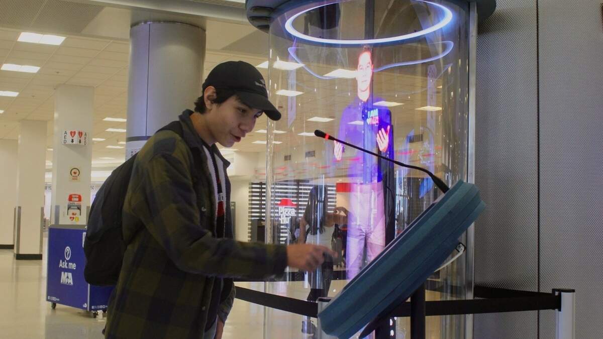 Jonathan Lopez stops to check out an AI hologram assistant in his trip from California, at Miami International Airport on July 1, 2026. Jonathan Lopez stops to check out an AI hologram assistant in his trip from California, at Miami International Airport on July 1, 2026.
