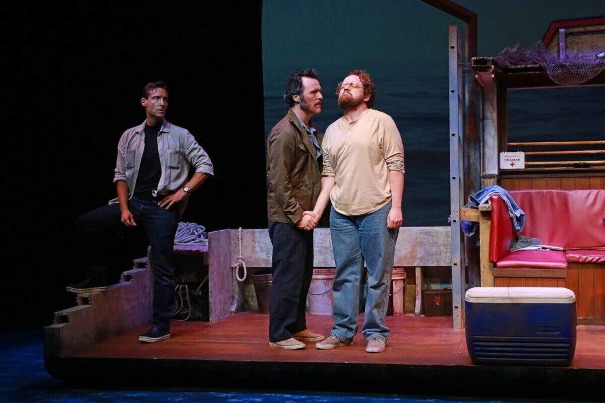 Tensions flare aboard the Orca as Robert Shaw (Iain Batchelor) twists Richard Dreyfuss’ (Wesley Slade) hand while Roy Scheider (Adam Poole) looks on in Actors’ Playhouse’s production of “The Shark Is Broken.”