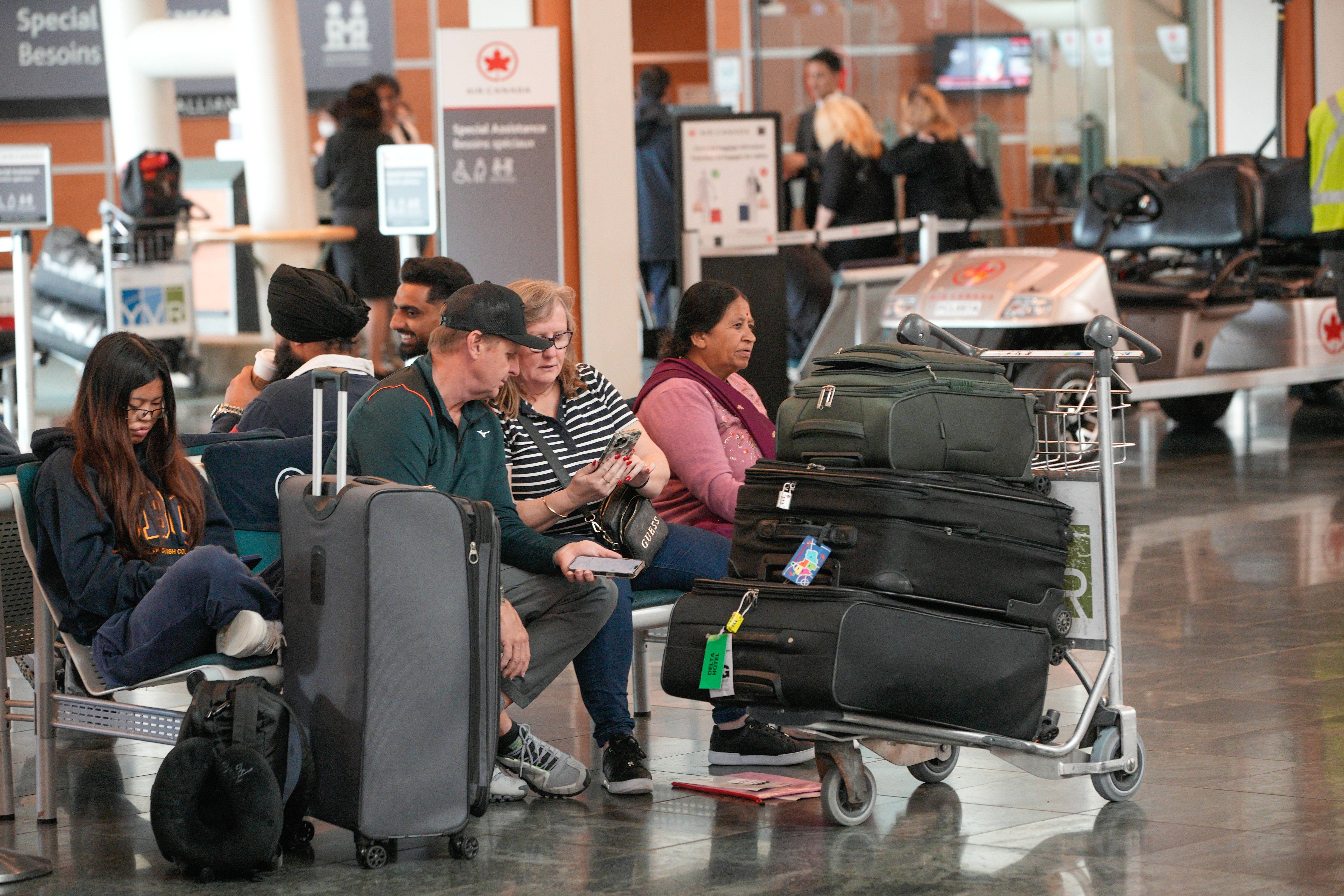 Passengers waiting at an Air Canada gate.