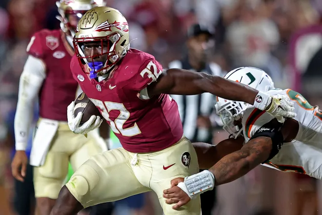 Ousmane Kromah (32) of the Florida State Seminoles rushes the ball past Malik Bryant of the Miami Hurricanes during the second quarter of the game at Doak S. Campbell Stadium on October 4, 2025 in Tallahassee, Florida. (Photo by Jason Clark/Getty Images)