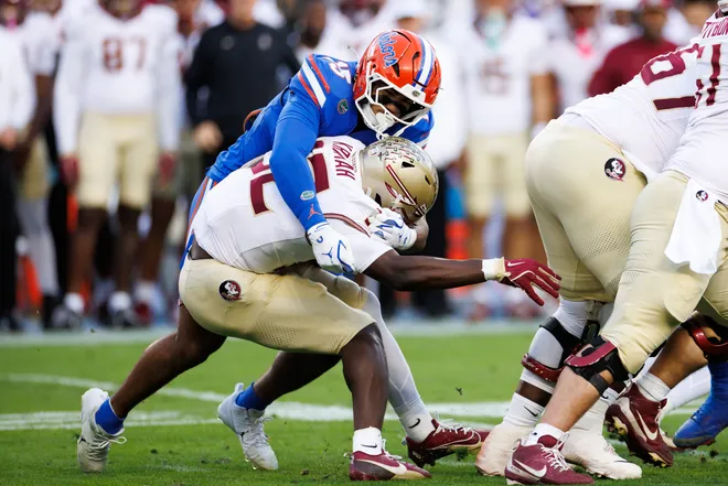 Nov 29, 2025; Gainesville, Florida, USA; Florida Gators defensive lineman Jayden Woods (15) tackles Florida State Seminoles running back Ousmane Kromah (32) during the first half at Ben Hill Griffin Stadium. Mandatory Credit: Matt Pendleton-Imagn Images