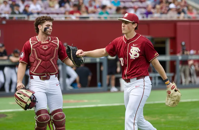 Hunter Carns (left) and Bryson Moore (right) fist bump as Florida State baseball beat James Madison 16-5 on Saturday, Feb. 14 at Dick Howser Stadium