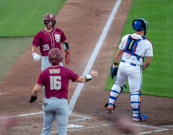 Florida State outfielder Brayden Dowd (16) and Florida State catcher Hunter Carns (25) score for Florida State against Florida, March 10, 2026, at Condron Family Ballpark in Gainesville, Florida. [Cyndi Chambers/ Gainesville Sun] 2026