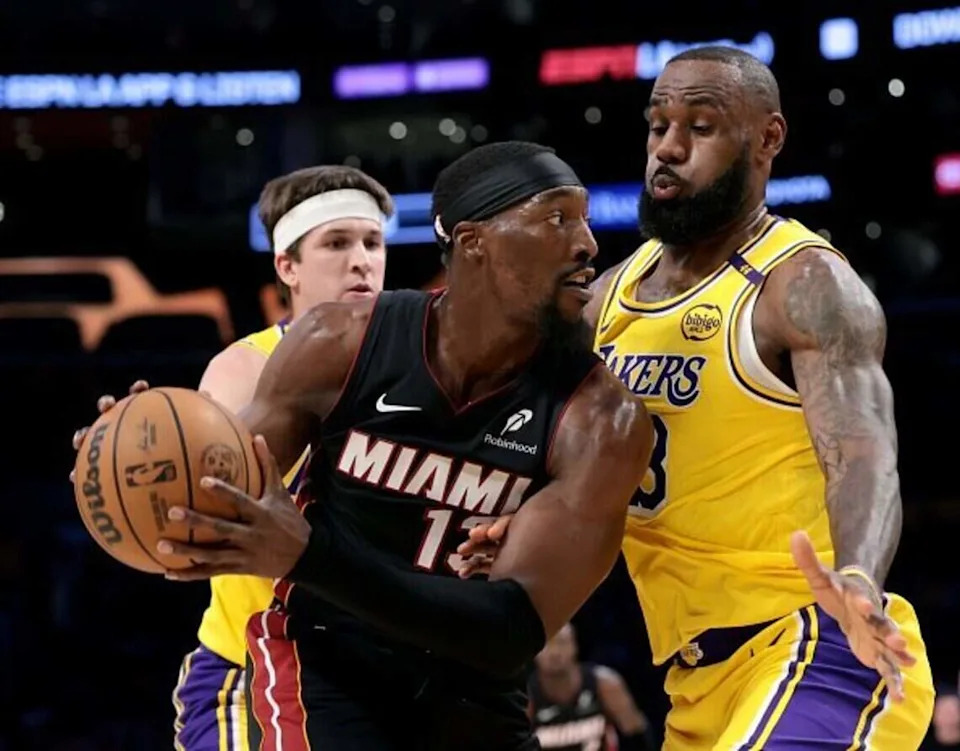 LOS ANGELES, CALIFORNIA - JANUARY 15: Bam Adebayo #13 of the Miami Heat keeps the ball from LeBron James #23 and Austin Reaves #15 of the Los Angeles Lakers during the first half at Crypto.com Arena on January 15, 2025 in Los Angeles, California. (Photo by Harry How/Getty Images) NOTE TO USER: User expressly acknowledges and agrees that, by downloading and/or using this Photograph, user is consenting to the terms and conditions of the Getty Images License Agreement. Mandatory Copyright Notice: Copyright 2025 NBAE. (Photo by Harry How/Getty Images)