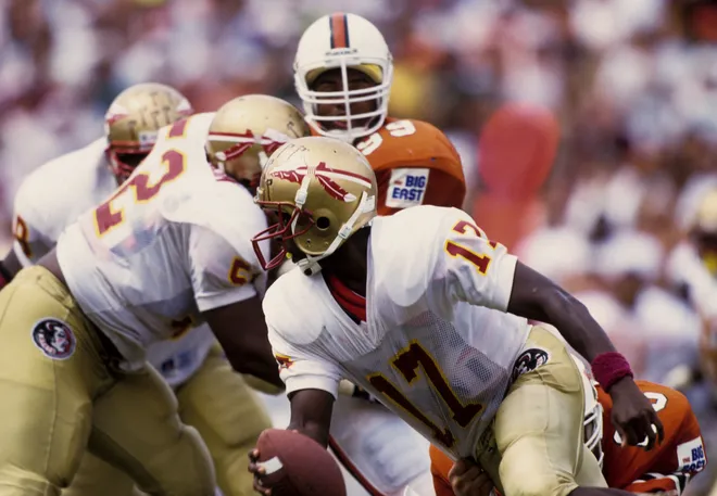 Oct 3, 1992; Miami, FL, USA: FILE PHOTO; Florida State Seminoles quarterback Charlie Ward (17) scrambles out of the pocket against Miami at the Orange Bowl. Miami defeated FSU 19-16. Mandatory Credit: USA TODAY Sports