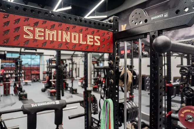 The Seminoles logo and branding is on each piece of equipment in the weight room inside the Florida State University Dunlap Football Center.