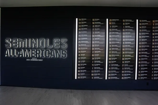 A hallway wall features past football players who earned All-American honors is displayed inside the Florida State University Dunlap Football Center.