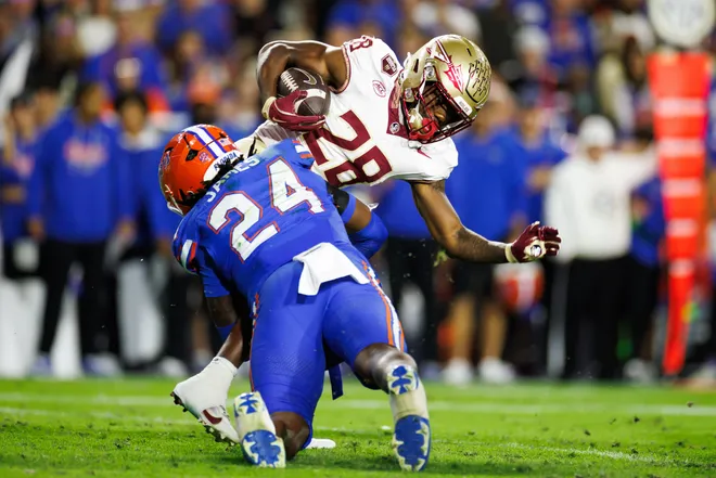 Nov 29, 2025; Gainesville, Florida, USA; Florida Gators defensive end Kamran James (24) tackles Florida State Seminoles running back Samuel Singleton Jr. (28) during the second half at Ben Hill Griffin Stadium. Mandatory Credit: Matt Pendleton-Imagn Images