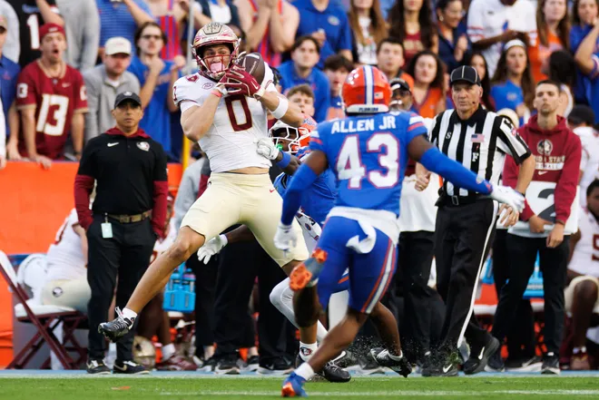 Nov 29, 2025; Gainesville, Florida, USA; Florida State Seminoles wide receiver Duce Robinson (0) makes a catch over Florida Gators cornerback J'Vari Flowers (6) during the first half at Ben Hill Griffin Stadium. Mandatory Credit: Matt Pendleton-Imagn Images