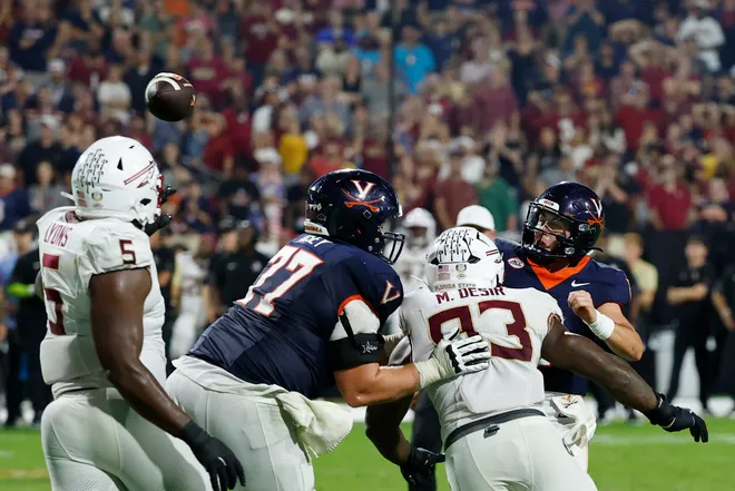 Sep 26, 2025; Charlottesville, Virginia, USA; Virginia Cavaliers quarterback Chandler Morris (4) completes a two point conversion as Florida State Seminoles defensive lineman Mandrell Desir (93) chases during the second overtime period at Scott Stadium. Mandatory Credit: Geoff Burke-Imagn Images