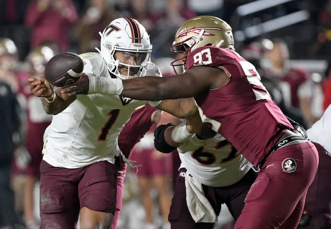 Nov 15, 2025; Tallahassee, Florida, USA; Virginia Tech Hokies quarterback Kyron Drones (1) has the ball knocked away by Florida State Seminoles defensive lineman Mandrell Desir (93) during the second half at Doak S. Campbell Stadium. Mandatory Credit: Melina Myers-Imagn Images