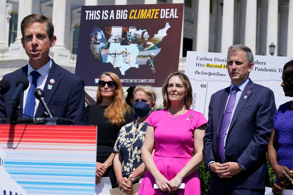 Democratic Rep. Kathy Castor of Florida, center in pink, listens as a colleague speaks about the climate crisis during a news conference on Capitol Hill in 2022.