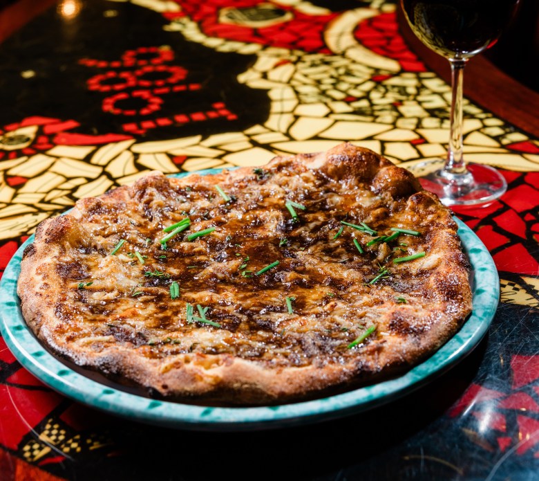 A pizza and a wine glass. 