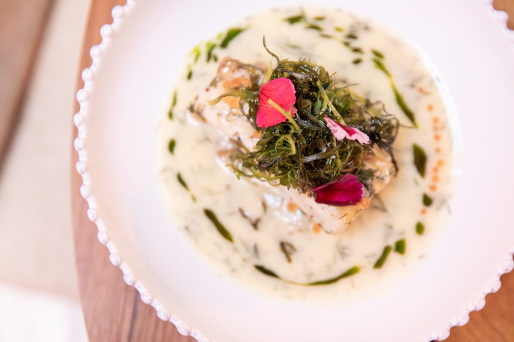 a seafood dish on a white plate with a cream sauce