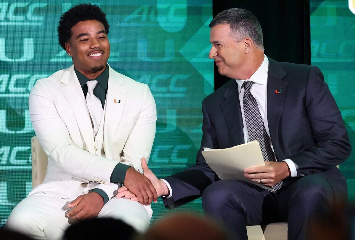 Miami Hurricanes quarterback Darian Mensah, left, shakes hands with head coach Mario Cristobal, right, during the 2026 ACC Football Kickoff program at the Hilton Charlotte Uptown Hotel in Charlotte, NC on Wednesday, July 15, 2026.