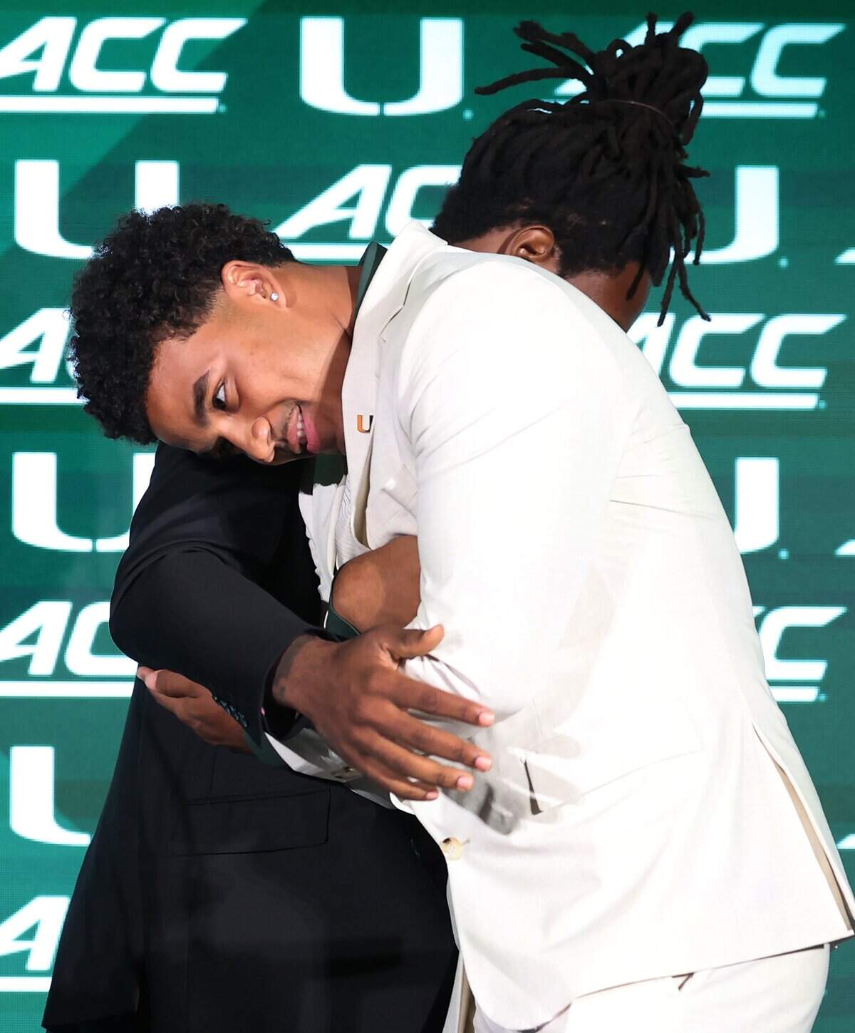 Miami Hurricanes running back Mark Fletcher Jr., left, hugs quarterback Darian Mensah, right, as he welcomes Mensah to the podium during the 2026 ACC Football Kickoff program at the Hilton Charlotte Uptown Hotel in Charlotte, NC on Wednesday, July 15, 2026.