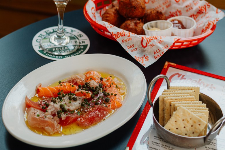 Fresh seafood and saltine crackers  next to a basket of hush puppies at Cheeky's