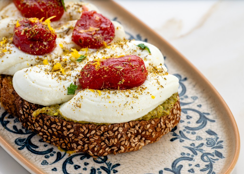 a cheese toast with red peppers on a porcelain blue and white plate