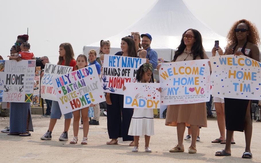 Families hold up colorful banners.