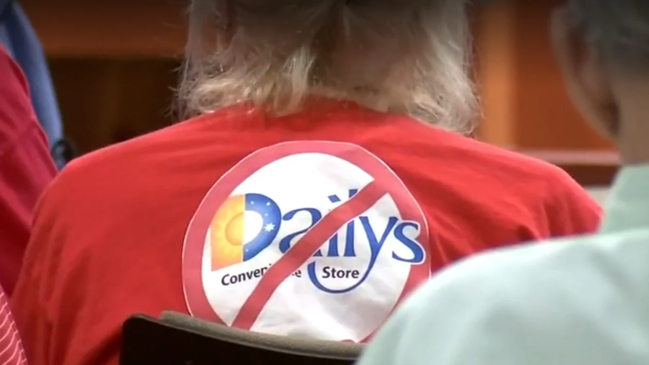 A resident wears a red shirt with a circle and slash through a Daily's logo.