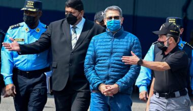 Honduras' former President Juan Orlando Hernandez (2-R) is escorted by Minister of Security Ramon Sabillon (R) towards a plane of the US Drug Enforcement Agency (DEA), during his extraditaton to United State at the Air force Base, in Tegucigalpa, on April 21, 2022.