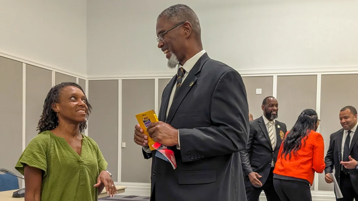 Marquita H. Green and Rhodesia "Rho" Butler speak with potential voters at an election forum sponsored by Alpha Phi Alpha Fraternity Inc.