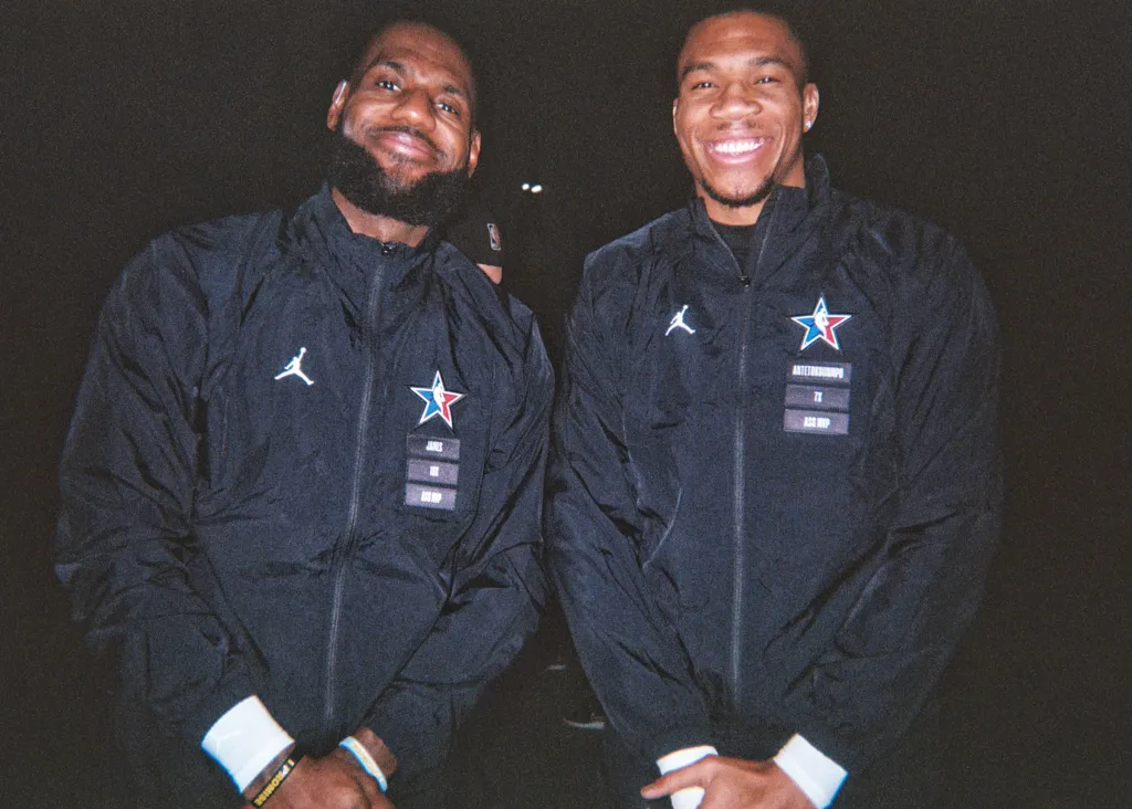 LeBron James and Giannis Antetokounmpo smiling in black All-Star jackets.