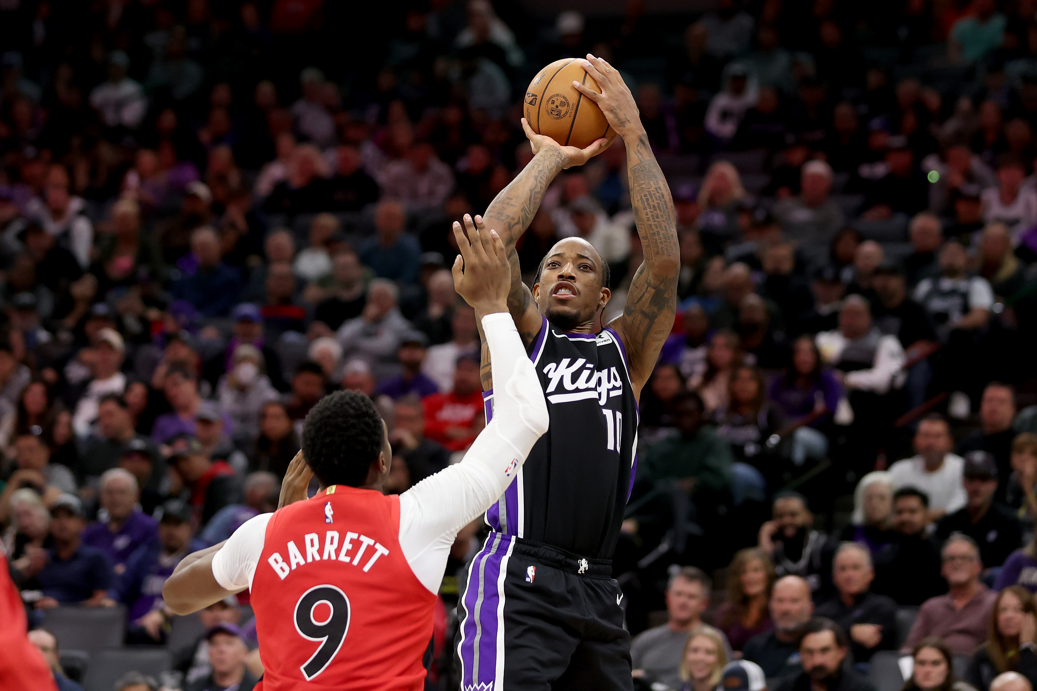 DeMar DeRozan shoots over RJ Barrett during a Sacramento Kings vs. Toronto Raptors NBA game amid speculation about a possible Raptors reunion.