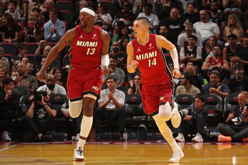 Bam Adebayo #13 and Tyler Herro #14 of the Miami Heat looks on during the game against the Milwaukee Bucks during the 2025-26 Emirates Cup on November 26, 2025 at Kaseya Center in Miami, Florida.