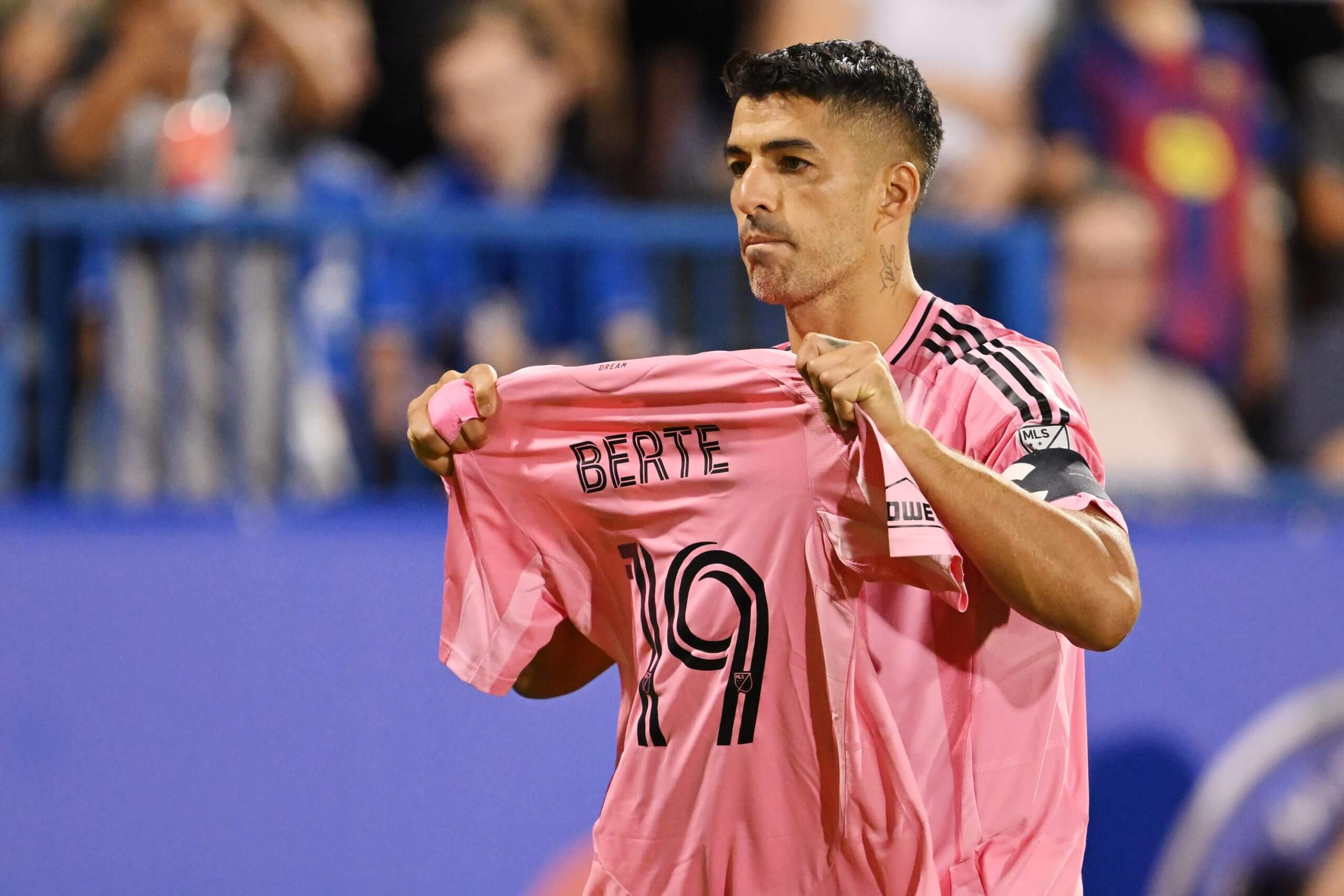 Image of Luis Suarez holding up his team-mate's shirt after scoring his penalty
