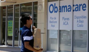 FILE - A man walks by an healthcare insurance office in Hialeah, Fla., July 27, 2017, (AP Photo/Ala...