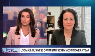 News broadcast split-screen: female anchor on left, guest in an office on the right during Bloomberg The Close interview.