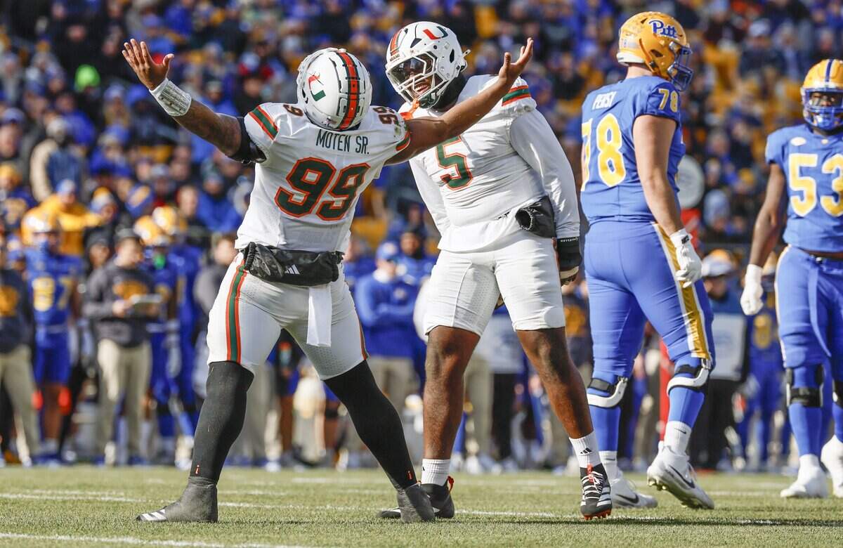 Miami Hurricanes defensive lineman Ahmad Moten (99) and defensive lineman Justin Scott (5) react after Moten sacks Pittsburgh Panthers quarterback Mason Heintschel (6) on the opening play of the game in the first half during their NCAA football game at Acrisure Stadium in Pittsburgh, PA, on Saturday, November 29, 2025.