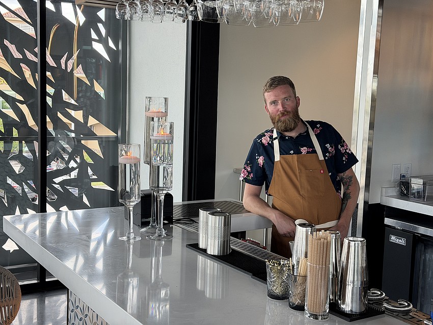 Corey Tighe, beverage director at Alder & Oak, is shown behind the bar at Zorbas, the rooftop bar atop the new restaurant in Jacksonville Beach